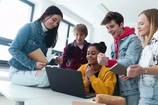 High school students working together around a computer